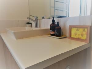 a bathroom counter with two bottles of wine and a sink at Wayamba in Warrnambool