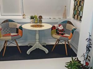 蒂米什瓦拉的住宿－The Kiss Apartment，一张桌子,两把椅子,一张桌子,上面有桑塔语句