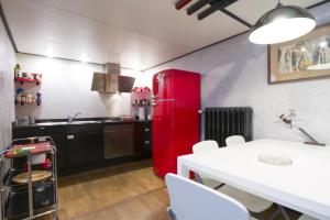 La cocina está equipada con nevera roja, mesa y sillas. en PrimoPiano - Guerrazzi, en Milán 30 fotos más