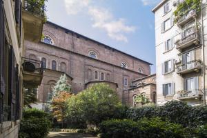un gran edificio de ladrillo junto a un edificio blanco en PrimoPiano - Guerrazzi, en Milán