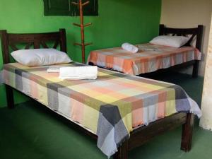 two beds in a room with green walls at Pousada Recanto Verde in Sao Benedito do Sul +67 photos