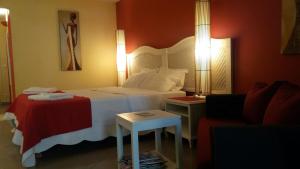 Habitación de hotel con cama y sofá en Résidence de la Vielle Tour - Studio particulier vue mer, en Le Gosier