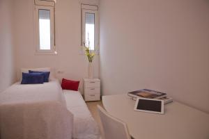 ein Schlafzimmer mit 2 Betten und einem Tisch mit einem Buch in der Unterkunft Balcones y Vistas en el Centro de la Ciudad in Barcelona