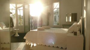 ein Schlafzimmer mit einem weißen Bett und einem Fenster in der Unterkunft Balcones y Vistas en el Centro de la Ciudad in Barcelona