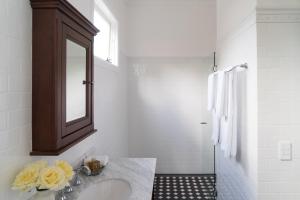 a white bathroom with a sink and a mirror at Loloma Bed and Breakfast in Armidale
