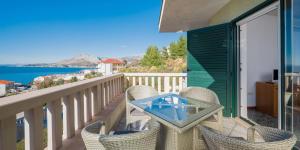 a balcony with a table and chairs and the ocean at Luxury Residence Omis in Omiš