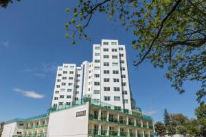 a tall white building in front of a blue sky at Quest on Durham in Tauranga