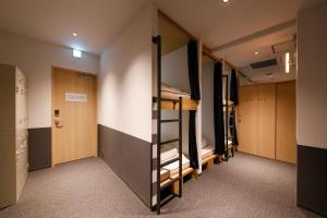 White Hostel Shinsaibashi في أوساكا: غرفة مع صف من الأسرّة بطابقين