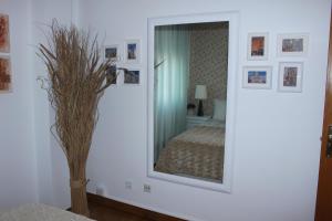 My apartment in Sacavém في شقبان: مرآة على جدار في غرفة مع سرير