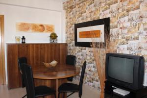 My apartment in Sacavém في شقبان: غرفة طعام مع طاولة وتلفزيون