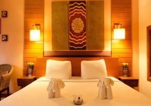 a hotel room with a bed, table, and lamps at Vieng Mantra Hotel in Chiang Mai