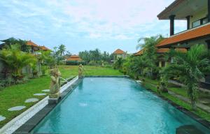 a swimming pool in front of a house at Sari Bungalow in Ubud