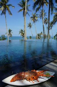 a lobster on a plate next to a body of water at Villa Tao in Tabanan