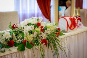 una mesa con flores rojas y blancas. en Park Hotel Bogorodsk, en Bogorodsk