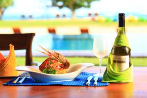 a table with a plate of food and a bottle of wine at Amaloh Boutique Resort in Matara