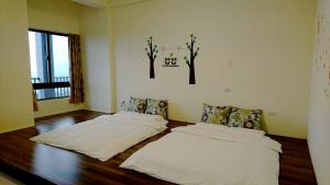 two beds in a room with wooden floors at Sun Moon Star in Xinshe