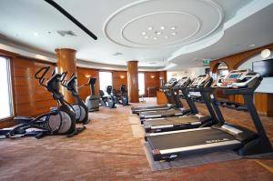 a gym with a row of treadmills and ellipticals at Amari Don Muang Airport Bangkok in Bangkok