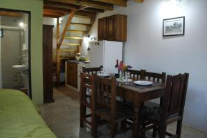 a kitchen with a table with chairs and a refrigerator at Apart Haiken in El Calafate