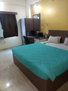 1 dormitorio con 1 cama y escritorio con ordenador en Hotel Fortune, en Patna