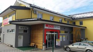 een geel gebouw met een bord ervoor bij B&B By The Way in Ljubljana