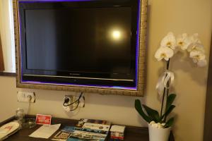 a television on a wall with a vase of flowers at Boğaz Otel in Çanakkale