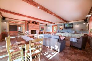 a kitchen and living room with a table and a couch at Villa Les with Hot tub & Sauna in Brežice