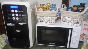 a microwave with baskets on top of it next to acomputer at B&B La Casa di Elsa in Marina di Massa