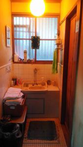a bathroom with a tub and a sink and a window at Homestay at Remote Organic Farm in Nachikatsuura