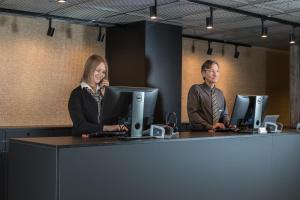 a man and a woman sitting at a desk with computers at Original Sokos Hotel Vaakuna Vaasa in Vaasa