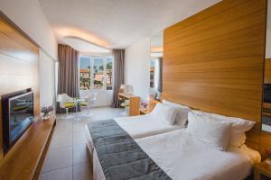 a hotel room with a bed and a television at Napa Plaza Hotel (Adults Only) in Ayia Napa