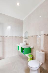 a bathroom with a white toilet and a sink at Lila Loka Homestay in Canggu