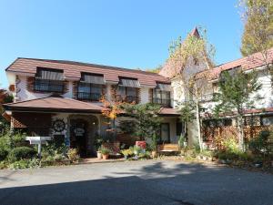 a large house with a driveway in front of it at Pension Eden in Naganohara