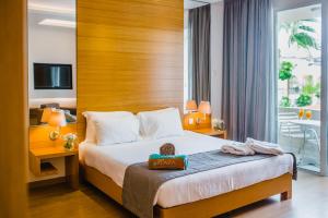a hotel room with a bed with a wooden headboard at Napa Plaza Hotel (Adults Only) in Ayia Napa