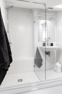 a bathroom with a glass shower and a sink at Deluxe Apartments by Hostlovers in Kaunas