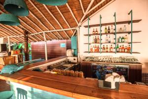 Un bar en un restaurante con un mostrador con alcohol. en SinQ Beach Morjim, en Morjim