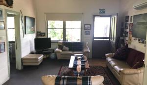 ein Wohnzimmer mit Sofas und einem Couchtisch in der Unterkunft Port Campbell Guesthouse & Flash Packers in Port Campbell