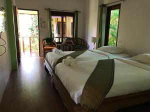 a bedroom with two beds with towels on them at Green Villa in Lamai