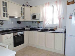 a kitchen with white cabinets and a white refrigerator at Can Vich in Santanyi