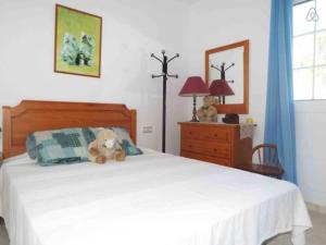 un osito de peluche sentado en una cama en un dormitorio en Can Vich, en Santanyí