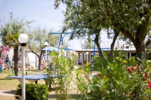 einen Park mit Spielplatz mit Schaukel in der Unterkunft Long Beach Village Residence sul mare spiaggia privata inclusa in Lido Adriano