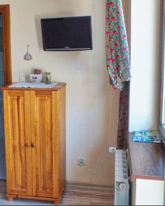 une chambre avec une télévision sur un mur et une armoire dans l'établissement Noclegi w centrum Sienkiewicza, à Zakopane