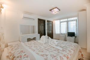 um quarto branco com uma cama grande e uma televisão em Patio Hotel em Antalya