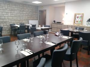 a dining room with tables and chairs with glasses on them at Logis Le Provençal in Euville