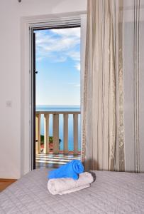 a bedroom with a bed with a view of the ocean at Apartments Mare in Brela