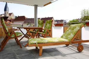 a patio with chairs and a table on a roof at Jakobshof in Bad Mergentheim