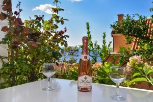 a bottle of wine sitting on a table with two glasses at Apartments Mare in Brela