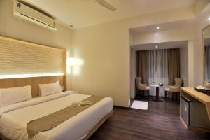 um quarto de hotel com uma cama grande e uma secretária em Rester Xpress Santacruz em Mumbai