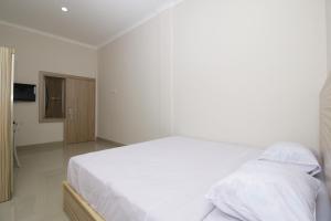 Postel nebo postele na pokoji v ubytování RedDoorz near Jalan Kolonel Haji Burlian Palembang
