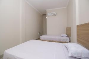 Postel nebo postele na pokoji v ubytování RedDoorz near Jalan Kolonel Haji Burlian Palembang