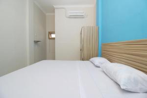 Postel nebo postele na pokoji v ubytování RedDoorz near Jalan Kolonel Haji Burlian Palembang